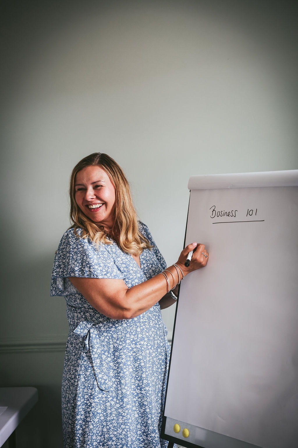 Sharon teaching beside a flipchart labelled Business 101
